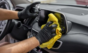 Hand cleaning the car interior with microfiber cloth towel
